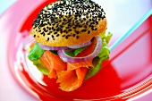A poppyseed roll filled with salmon, onions and salad