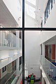 View through a glass stairwell into an atrium of a college with modern design with a skylight and see through balustrades (Oxford and Cherwell Valley College)