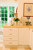 Country-house kitchen in pale shades with base unit running around corner