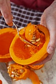 Hokkaido pumpkin being scooped out with a spoon