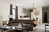 Minibar auf Couchtisch und braunes Sofa vor Essplatz in offenem Wohnraum in klassisch modernem Stil