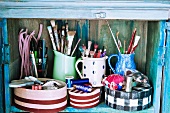 Assorted sewing and craft supplies in an old wooden cupboard