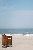 Umkleidekabine aus Holz an einsamen Sandstrand