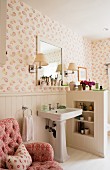 Pink button tufted armchair in bathroom with dado wood panelling and Kathryn Ireland Quilt wallpaper