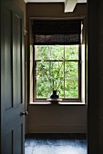 Cut flowers on windowsill in home of fabric designer Richard Smith in East Sussex