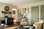 Vintage-style living area with free-standing log-burner in front of fireplace and view into bright room in background