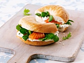 Cream cheese, bittercress and smoked salmon bagel on a chopping board