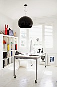 Mobile desk under black pendant lamp in modern interior