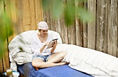 Lady with an iPad on a garden sofa