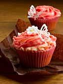 Cupcakes decorated with strawberry cream, butterflies and sugar flowers