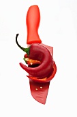 Half a red chilli pepper on a red knife