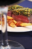 Beef fillet with a herb crust and melon wrapped in bacon