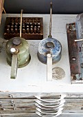 Vintage oil cans on chest of drawers