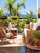 Sunny terrace seating area - wicker sofa and armchair with curved metal frame in front of palm trees and sea view