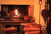 Traditioneller Backsteinkamin mit brennendem Feuer in warmem Licht