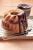 Marble cake on a cooling rack, partially coated with chocolate glaze