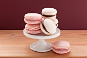 A small cake stand with pink macaroons and white macaroons with chocolate filling