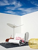weiße Designer Sonnenliege mit integriertem Sonnenschirm und Abstellfläche auf einer Terrasse