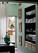 View of towels on shelves in niche next to terrace door across corner of washstand