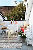 Small seating area with garden furniture, sequinned rug and white, Oriental lantern on modern roof terrace with narrow view