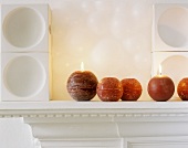 Lit sphere candles on mantelpiece
