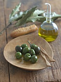 Green Olives with Olive Oil on a Wooden Dish; Carafe of Olive Oil
