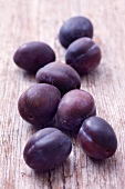 Plums on a wooden surface