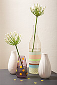 Decorative vases with and without flowers on a grey table