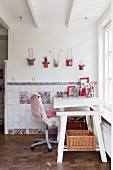 White adjustable desk and sheepskin on desk chair below creative wall decorations and hand-made traditional wall tiles