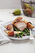 Crackling roast of pork with pears, beans and bacon