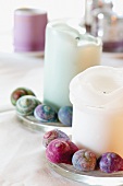 Candles wreathed with colourful snail shells on dining table