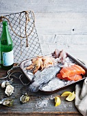 Fish and seafood in a roasting dish with ice on a rustic wooden table