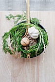 An arrangement of dill, garlic and peppercorns (seen from above)