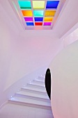 Kugelförmiger Einbau in modernem Treppenhaus und Lichtfeld mit farbigen Glaselementen im Deckenbereich