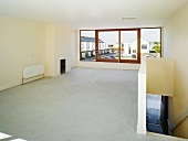 Empty room with staircase and view of housing estate through widow