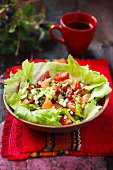 Salmon salad with tomatoes, feta cheese and pomegranate seeds on iceberg lettuce