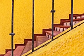 Staircase with sunshine yellow walls, red treads and tiled risers