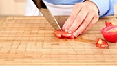 A tomato being chopped