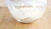 Buttermilk being added to a flour and vegetable fat mixture