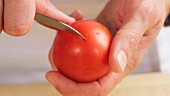 A tomato being scored with a cross