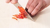 Deseeded chilli being sliced into fine strips