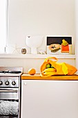 Kitchen shelf with still life; including a yellow shopping bag with fresh fruit