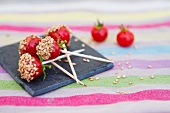 Cherry tomatoes on sticks with sesame seeds