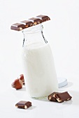A bottle of milk and a piece of wholenut chocolate