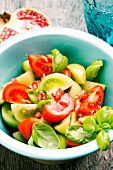 A salad with green and red tomatoes, basil and pomegranate seeds