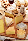 Various types of cheese, nuts, bread and red wine