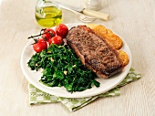 Beef steak with spinach, tomatoes and potatoes