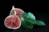 A halved fig with a fig leaf