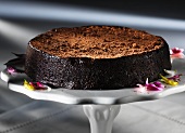 A chocolate truffle cake on a cake stand