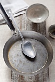A spoon in an old iron pan